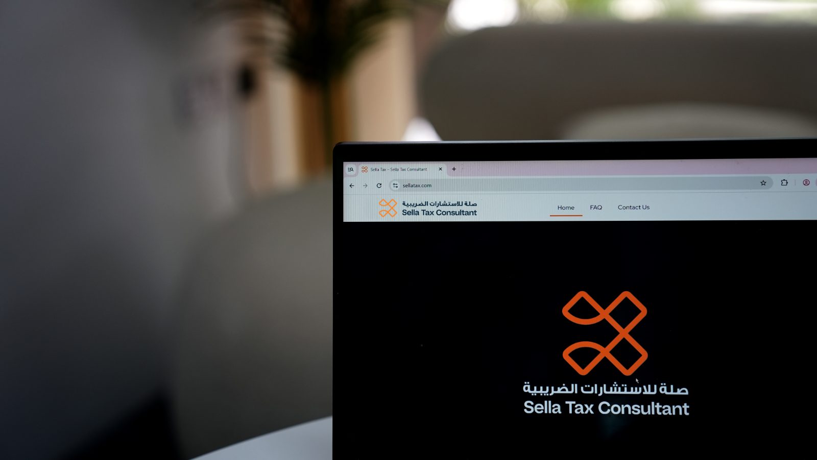 Close-up of a laptop screen displaying the sellatax.com homepage.
